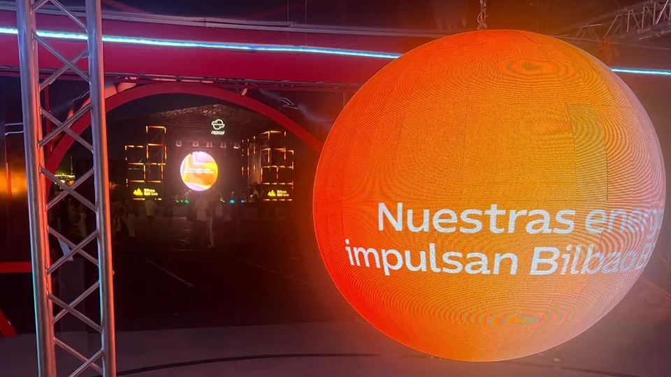 Esfera LED iluminada en naranja dentro de la instalación del festival.
